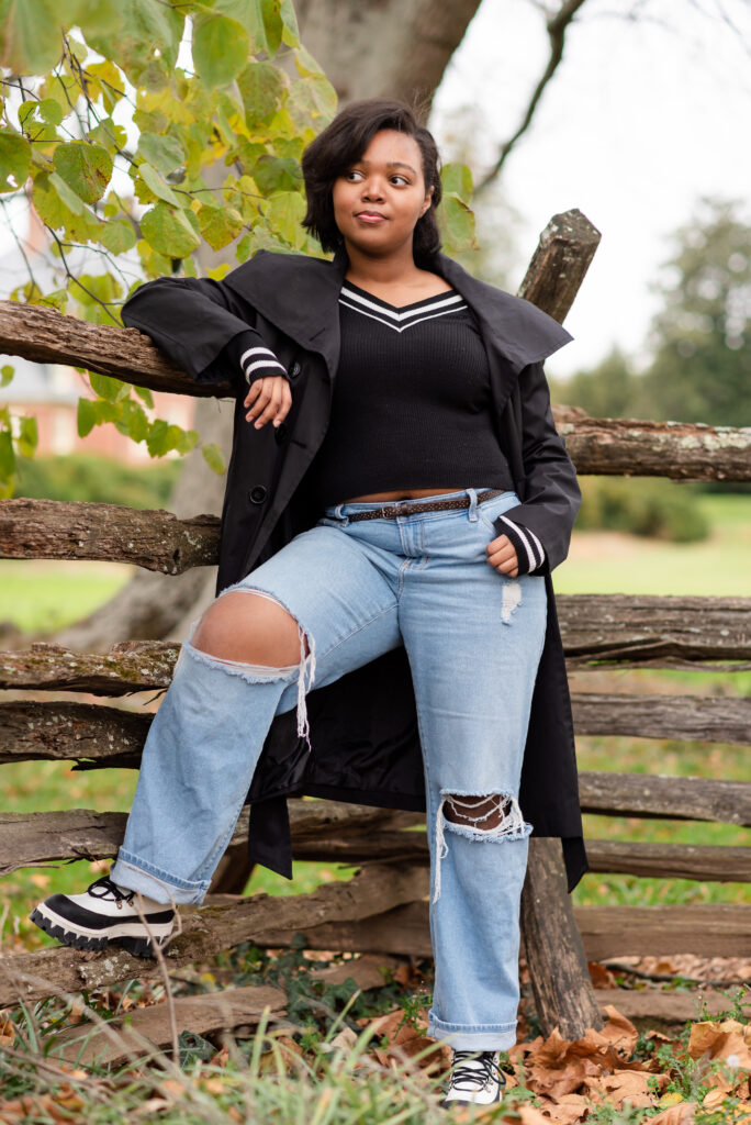 Senior graduate standing by wooden fence at Montpelier Mansion for senior graduate photos